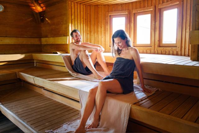 Junges Pärchen sitzt entspannt in der Sauna